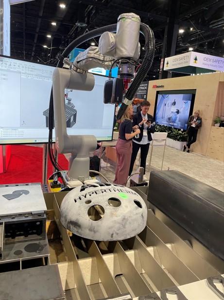 A cobot projects a target on a tank vessel head where the plasma cutting is to take place.