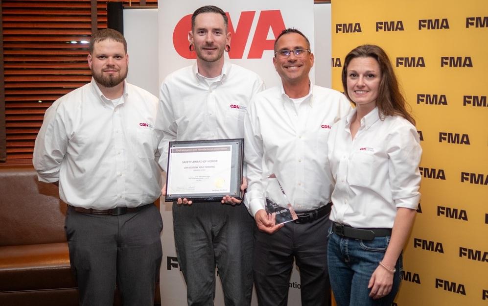CDH Custom Roll Form employees pose with a plaque and trophy at the FMA Safety Conference awards dinner.
