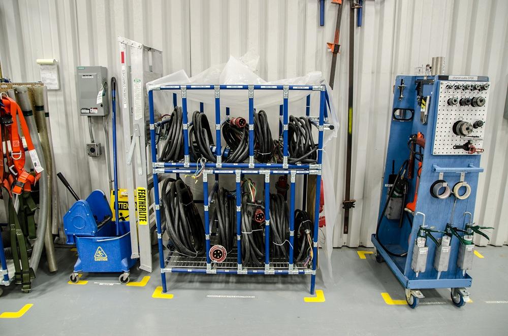 Cable and work tools are neatly organized in a manufacturing work area.