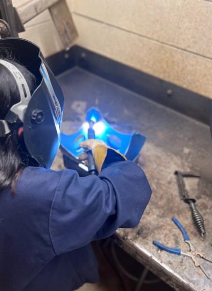 Students turn on light bulbs with welding